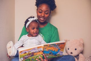 Babysitter reading book to toddler.