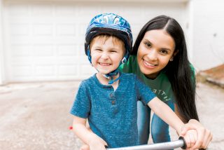 safe sitter and young boy wearing a helmet while bike riding